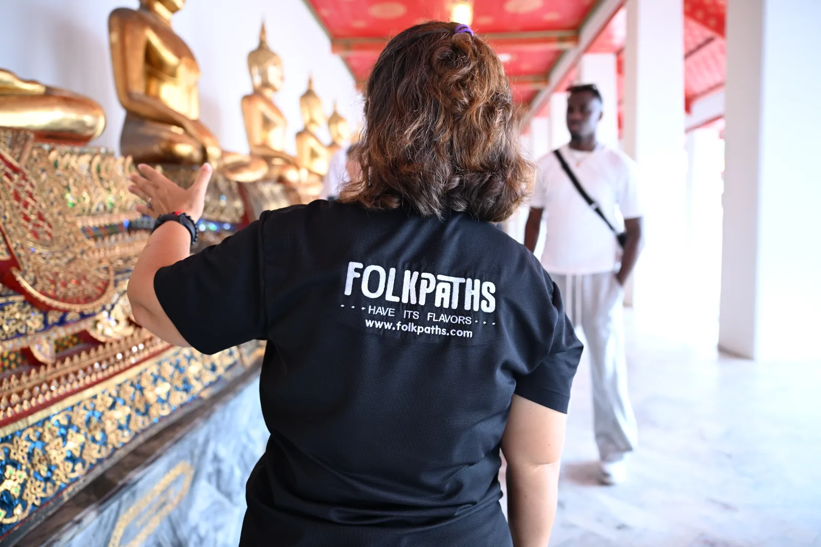 A Folkpaths guide explaining temple details to a guest at Wat Pho