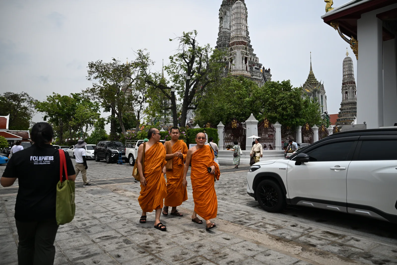 A Folkpaths guide and Buddhist monks passing through the grounds of Wat Arun